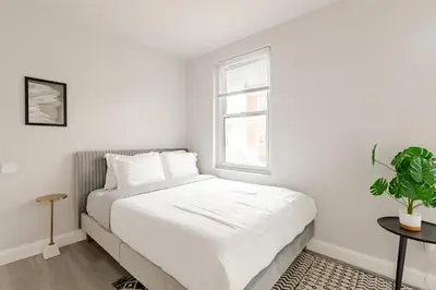 a white bedroom with a bed and a window at Philly Getaway - Chic Stay Near Center City in Philadelphia