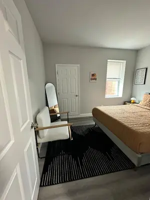 a bedroom with a bed and a chair and a door at Philly Getaway - Chic Stay Near Center City in Philadelphia
