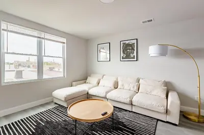 a white living room with a couch and a table at Philly Getaway - Chic Stay Near Center City in Philadelphia