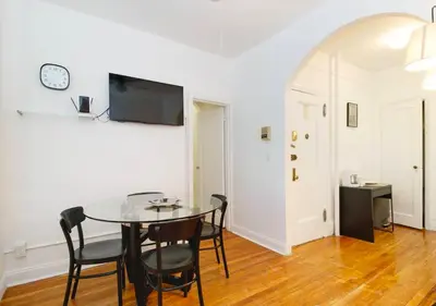 a dining room with a table and chairs and a clock at Outdoor Space Washer Dryer Dishwasher 3Beds Apt, June to Aug 90 days stay required in New York