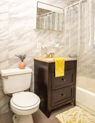 a bathroom with a toilet and a sink and a tub at 3BR Loft! Mins to Time Square!, June to Aug 90 days stay required in New York