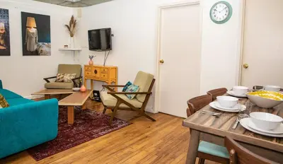 a living room with a table and chairs at 3BR Loft! Mins to Time Square!, June to Aug 90 days stay required in New York