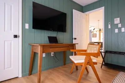 a room with a desk and a tv on a wall at Scandinavian Retreat Hot Tub, Pool, Game Rm in Gouldsboro