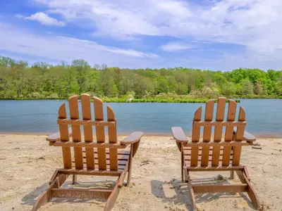 two chairs sitting on a beach near a body of water at Scandinavian Retreat Hot Tub, Pool, Game Rm in Gouldsboro