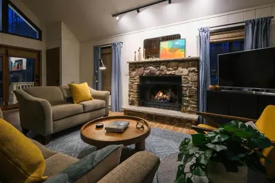 a living room with a fireplace and a tv at Scandinavian Retreat Hot Tub, Pool, Game Rm in Gouldsboro
