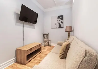 a living room with a couch and a flat screen tv at Chelsea 2BR Gem! in New York