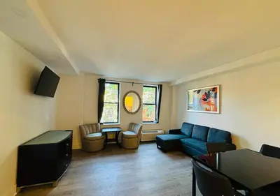 a living room with a blue couch and a table at Central Park West Furnished 1 Bedroom Apartment in New York