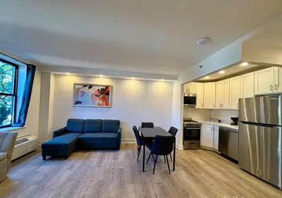 a living room with a blue couch and a table at Central Park West Furnished 1 Bedroom Apartment in New York