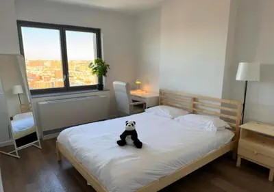 a panda bear sitting on a bed in a bedroom at Newly Reno 1BR! Murray Hill! in New York