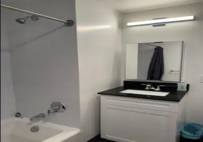 a white bathroom with a sink and a mirror at Newly Reno 1BR! Murray Hill! in New York