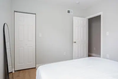 a bedroom with two white doors and a bed at Stylish Stay in Center City, French-Japanese & Minimalist Vibes in Philadelphia