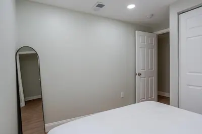 a bedroom with a white bed and a mirror at Stylish Stay in Center City, French-Japanese & Minimalist Vibes in Philadelphia