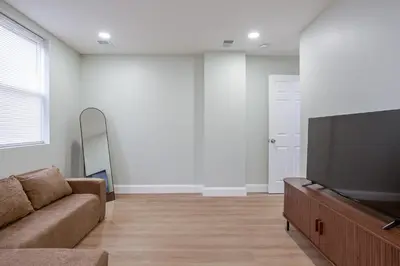 a living room with a couch and a flat screen tv at Stylish Stay in Center City, French-Japanese & Minimalist Vibes in Philadelphia