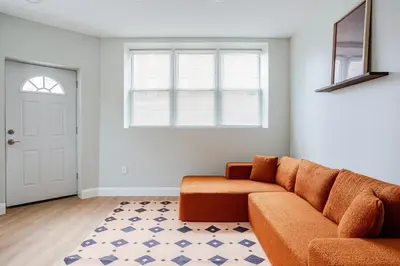 a living room with a couch and a window at Stylish Stay in Center City, French-Japanese & Minimalist Vibes in Philadelphia