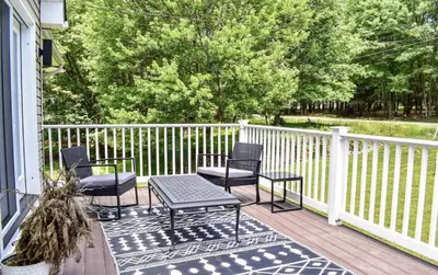 a porch with two chairs and a table on a deck at Poconos Chalet Hot Tub, Game Room, Sleeps 10 in Albrightsville