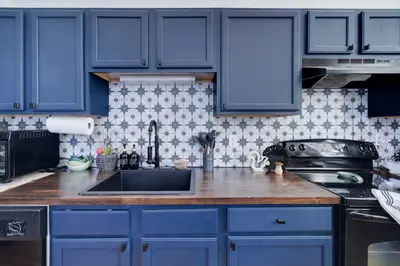 a kitchen with blue cabinets and a sink at Poconos Chalet Hot Tub, Game Room, Sleeps 10 in Albrightsville