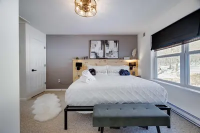 a bedroom with a large white bed and a window at Poconos Chalet Hot Tub, Game Room, Sleeps 10 in Albrightsville