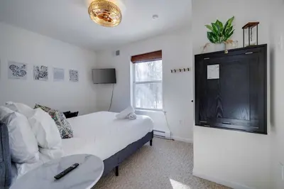 a bedroom with a bed and a table and a window at Poconos Chalet Hot Tub, Game Room, Sleeps 10 in Albrightsville
