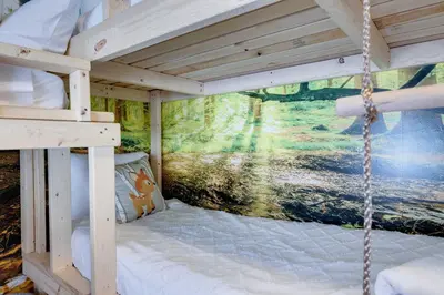 a bunk bed in a room with a painting on the wall at Poconos Chalet Hot Tub, Game Room, Sleeps 10 in Albrightsville