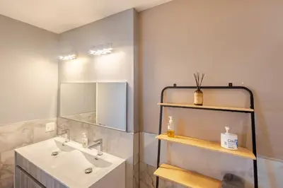 a bathroom with a sink and a mirror at Stylish SOHO-Inspired Loft, 15 Min to NYC Times Square in Union City