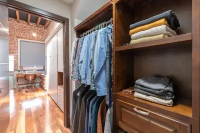 a walk in closet filled with lots of clothes at Stylish SOHO-Inspired Loft, 15 Min to NYC Times Square in Union City