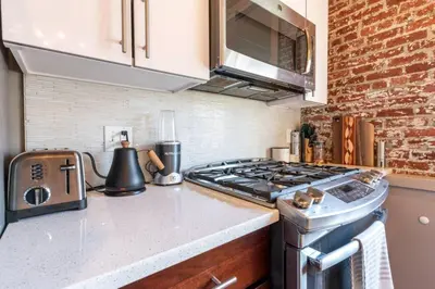a kitchen with a stove and a counter top at Stylish SOHO-Inspired Loft, 15 Min to NYC Times Square in Union City