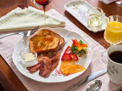 a plate of breakfast food with eggs bacon and toast at Mooreland Garden Inn in Carlisle