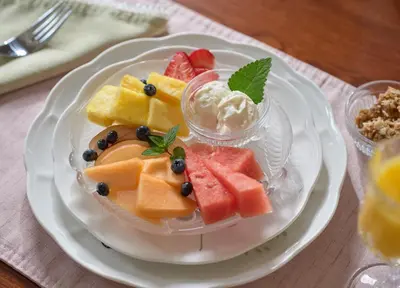 a plate with a bowl of fruit and ice cream at Mooreland Garden Inn in Carlisle