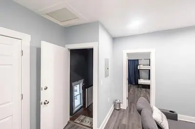 a white living room with a couch and a bedroom at Prime Location Explore NYC in West New York
