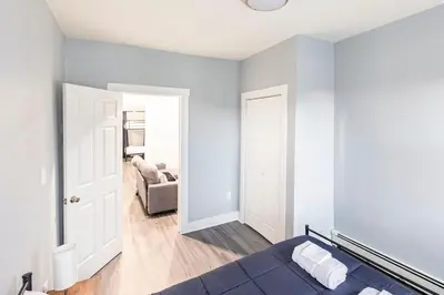 a bedroom with a blue bed and a couch at Prime Location Explore NYC in West New York