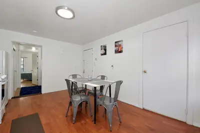 a dining room with a table and chairs at Cozy 2BR Apartment in the Heart of Chelsea in New York