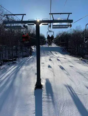 a ski lift with people on it in the snow at Huge Masthope retreat king sz bed , hot tub , game room in Lackawaxen
