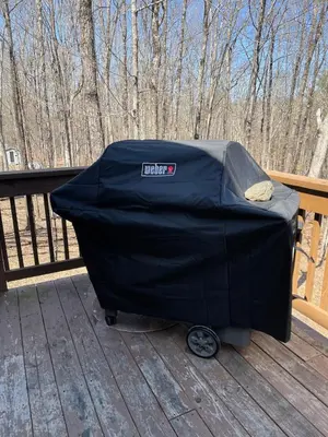 a black cover on a deck with trees in the background at Huge Masthope retreat king sz bed , hot tub , game room in Lackawaxen