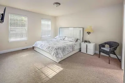 a bedroom with a bed and a chair and a lamp at Huge Masthope retreat king sz bed , hot tub , game room in Lackawaxen