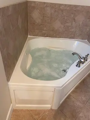 a bath tub filled with water in a bathroom at Huge Masthope retreat king sz bed , hot tub , game room in Lackawaxen