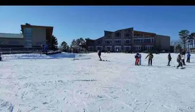 a group of people standing in the snow in front of a building at Huge Masthope retreat king sz bed , hot tub , game room in Lackawaxen