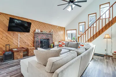 a living room with a couch and a fireplace at 3 Mi to Tobyhanna State Park Home with Serene Deck! in Tobyhanna