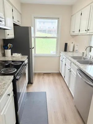 a kitchen with a stove and a sink and a window at Town House near Geisinger Medical Center in Danville