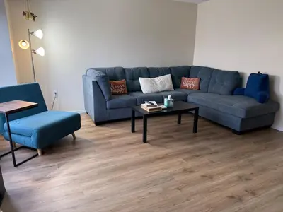 a living room with a blue couch and a table at Town House near Geisinger Medical Center in Danville