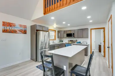 a kitchen with a counter and chairs in it at Lakefront Poconos Cabin with Deck and Game Room in Pocono Lake