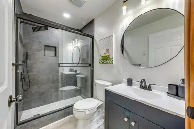 a bathroom with a toilet and a sink and a mirror at Lakefront Poconos Cabin with Deck and Game Room in Pocono Lake