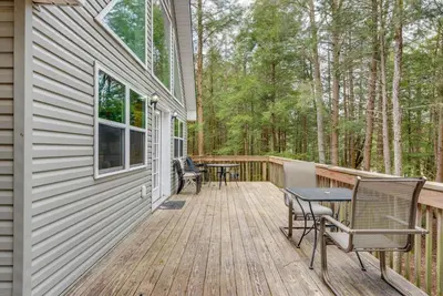 a wooden deck with a table and chairs on it at Lakefront Poconos Cabin with Deck and Game Room in Pocono Lake