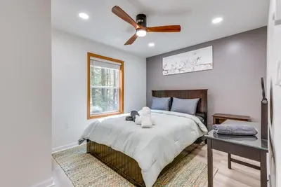 a bedroom with a bed with a ceiling fan at Lakefront Poconos Cabin with Deck and Game Room in Pocono Lake