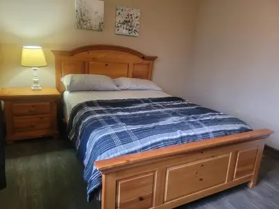 a bedroom with a bed and a dresser with a lamp at CareHouse Residence in Lawnside