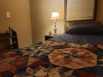 a quilt on a bed in a bedroom with a lamp at CareHouse Residence in Lawnside