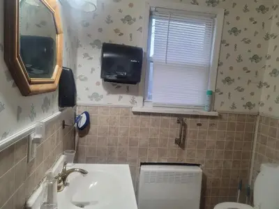 a bathroom with a sink and a toilet and a window at CareHouse Residence in Lawnside