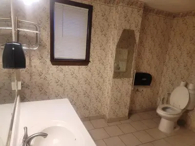 a bathroom with a toilet and a sink and a window at CareHouse Residence in Lawnside