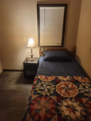 a bedroom with a bed with a quilt on it at CareHouse Residence in Lawnside