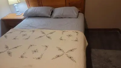 a bed in a bedroom with a blanket on it at CareHouse Residence in Lawnside