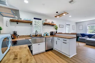 a kitchen with white cabinets and wooden floors at Cozy 2 Bedroom apartment in Tannersville, minutes from Camelback Mountain in Tannersville